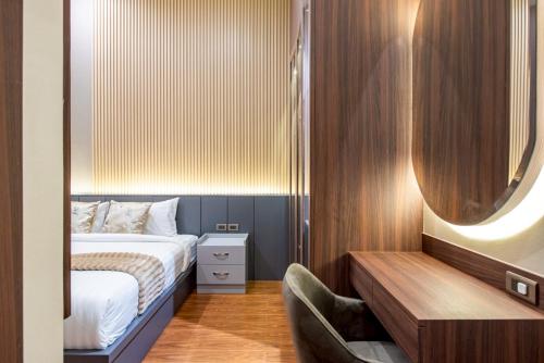 a small bedroom with a bed and a mirror at Cheeky monkey villa in Nong Prue