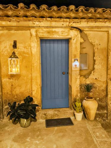 a blue door on the side of a building with plants at B&B Nonna Cristina in Nardodipace