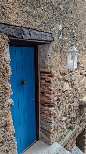 a blue door on a stone building with a light at B&B Nonna Cristina in Nardodipace