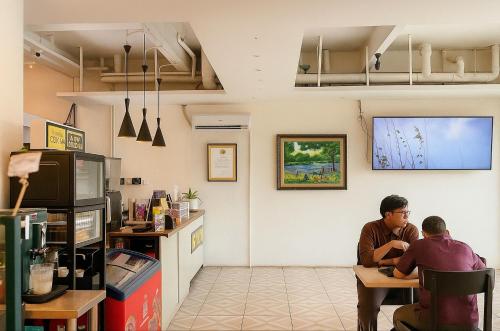 two people sitting at a table in a restaurant at Anders Arjuna Selatan in Jakarta