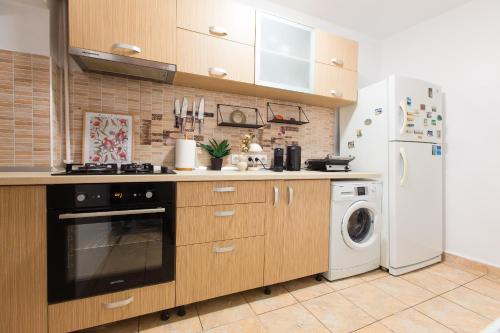 a kitchen with a refrigerator and a washer and dryer at Central 2-Bedroom House with Shared Courtyard near Old Town Bucharest in Bucharest