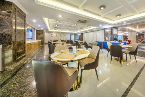 a restaurant with tables and chairs in a room at ST Hotel Wattay Airport in Vientiane