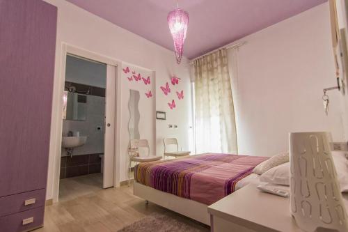 Habitación púrpura con cama y baño en La Sfinge BeB, en San Salvo