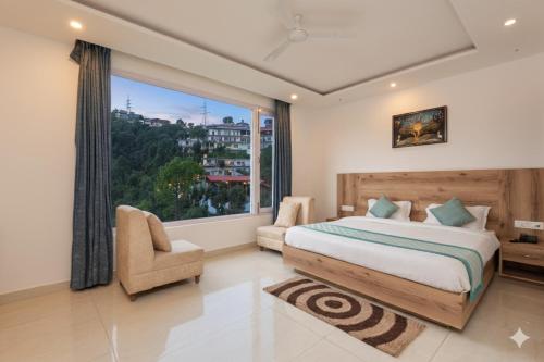 a bedroom with a bed and a large window at Hotel Moonglade By Royal Stays Dalhousie in Dalhousie