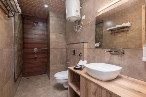 a bathroom with a sink and a toilet at Hotel Moonglade By Royal Stays Dalhousie in Dalhousie
