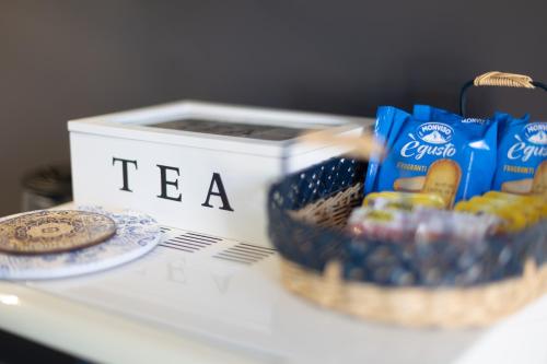 a table with a box of tea and a basket of cookies at Casa Vacanza "Marinella" in Sulmona