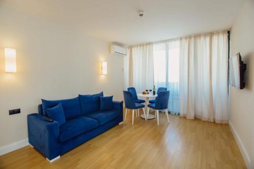 a living room with a blue couch and a table at Orbi City Premium Sea View Apartments in Batumi