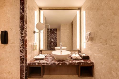 un baño con lavabo y espejo en Lemon Tree Premier, Navi Mumbai, en Navi Mumbai