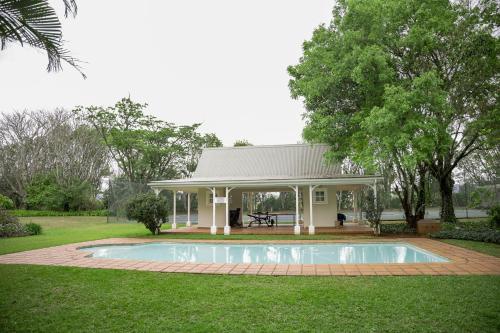 a house with a swimming pool in the yard at Umdoni Farm Lodge in Mahlanya