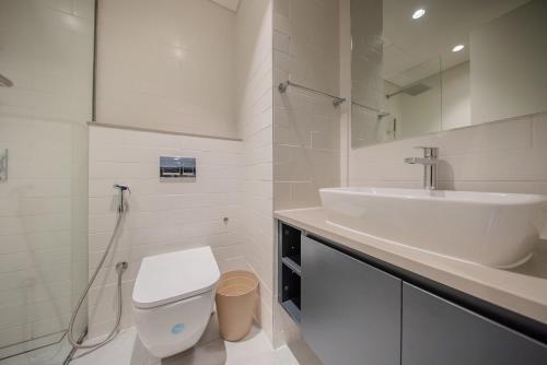 une salle de bain blanche avec un lavabo et des toilettes dans l'établissement Private Luxury Studio Apartment in AlJada by Arada, à Charjah