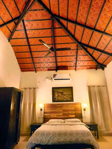 a bedroom with a large bed with a wooden ceiling at The Road's End in Gonikoppal