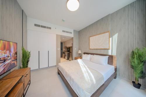une chambre avec un lit et une télévision à écran plat dans l'établissement Private Luxury Studio Apartment in AlJada by Arada, à Charjah