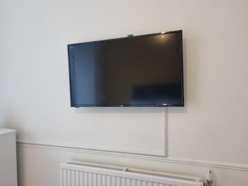 Un televisor de pantalla plana colgado en una pared blanca en Kingfield Boutique Hotel, en Nether Edge