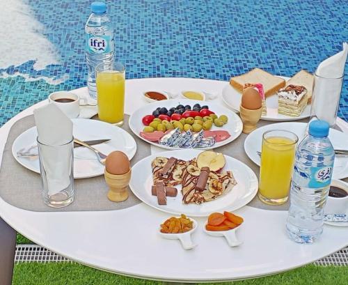 a table with plates of food and drinks on it at Residance touristique marcadal by mon rêve in Fort de lʼEau