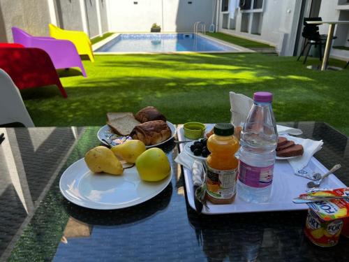 a table with a tray of food and bottles of juice at Residance touristique marcadal by mon rêve in Fort de lʼEau