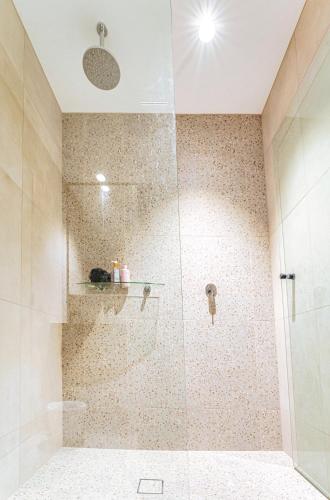 a bathroom with a shower with a glass door at 412 on CODA Oasis with Mountain View in Coffs Harbour