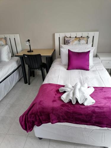 un letto bianco con due asciugamani bianchi di Ngwanase Properties a Durban