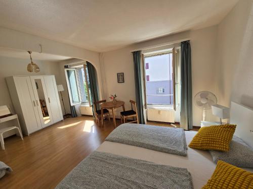 a bedroom with two beds and a table with a desk at My Room Luzern in Luzern