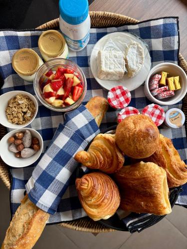 einen Teller mit Gebäck und anderen Lebensmitteln auf dem Tisch in der Unterkunft La Petite Adresse du 10Honfleur in Honfleur