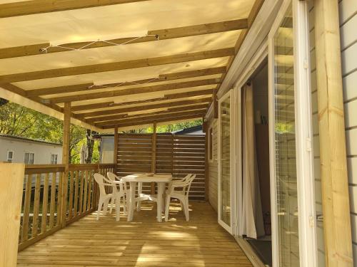 a wooden deck with a table and chairs on it at Farniente en Cévennes in Génolhac