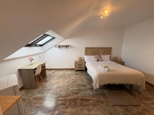 a bedroom with a bed and a desk and a window at Hotel Rural O Salazón in Cambados