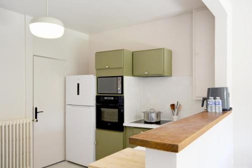 a kitchen with green cabinets and a white refrigerator at Docatange in Boisgasson