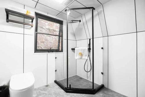 una ducha con puerta de cristal en un baño en VERDANT HAVEN, en Jiezi Ancient Town