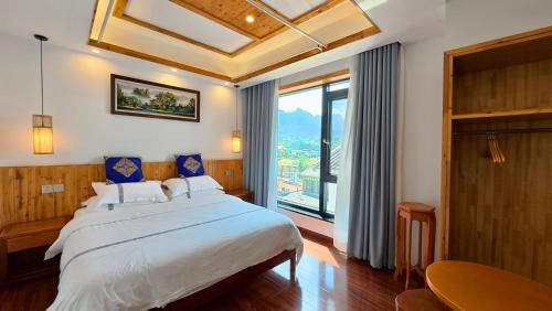 a bedroom with a large bed and a large window at Yesuhanshe Homestay in Zhangjiajie