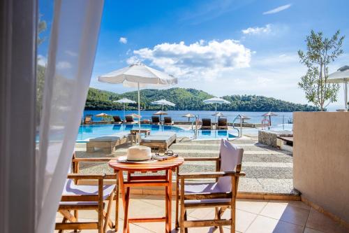 a patio with a table and chairs and a pool at Blue Green Bay in Panormos Skopelos