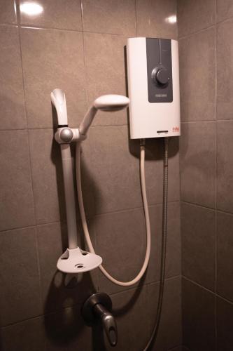 a phone on the wall of a shower in a bathroom at Baan Paea Guest House in Ban Ket Ho