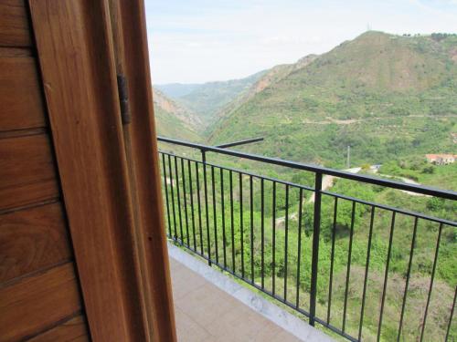 a room with a balcony with a view of a mountain at B&B Serena in Longi