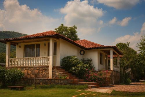 a white house with a porch and stairs at Virat Resorts, Sariska Rajasthan in Bairāt