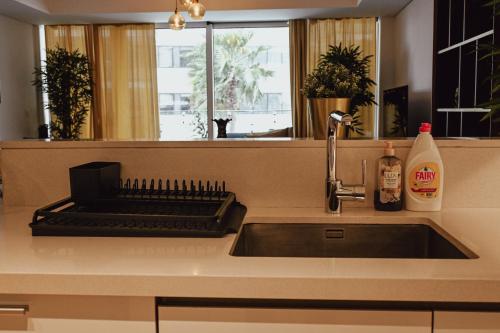 a kitchen sink with a keyboard and a window at Beachside Sunset Residence in Abu Dhabi