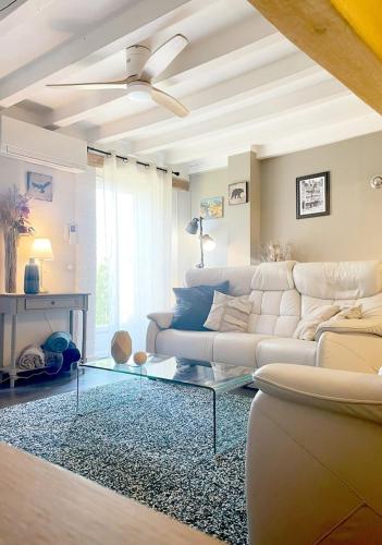 a living room with a white couch and a ceiling fan at La Serenidad in Denonville