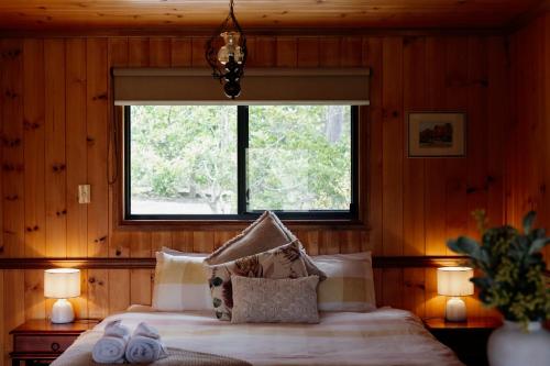Ένα ή περισσότερα κρεβάτια σε δωμάτιο στο Tuckeroo Cottages & Gardens - Blue Wren & Kookaburra