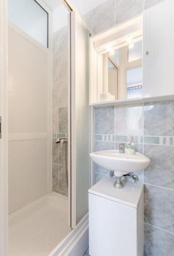 a white bathroom with a sink and a shower at Apartment Matko in Mirce