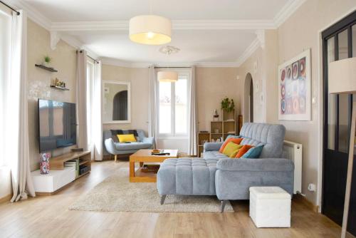 Una sala de estar con un sofá azul y un televisor. en La Milena, en Morancez