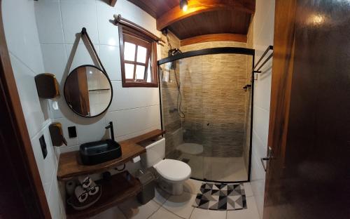 a bathroom with a shower and a toilet and a mirror at Chale Recanto do Lago in Itu