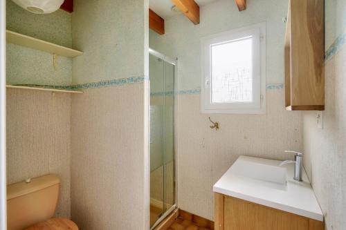 a bathroom with a sink and a toilet and a window at Plobannalec-Lesconil centre - Maison avec grand jardin in Plobannalec-Lesconil