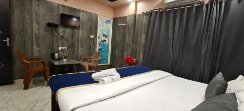 een slaapkamer met een bed, een bureau en een tafel bij Sheshu Homestay in Māvalli