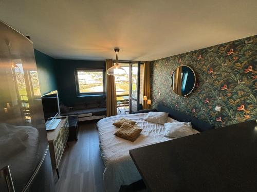 a bedroom with a bed and a mirror on the wall at Une escapade à l'estacade in Deauville