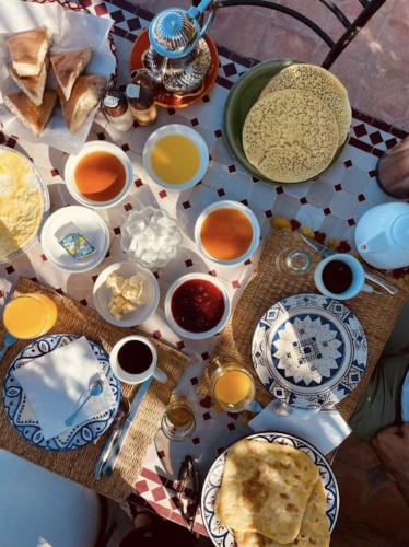 uma mesa com pratos e tigelas de comida sobre ela em Riad Lailouza em Essaouira