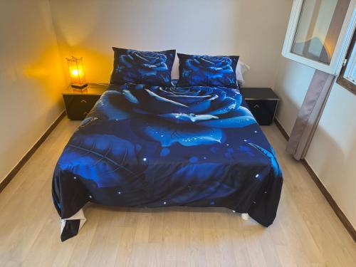Una cama con un edredón azul en un dormitorio. en Maison provençale de charme, en Velaux