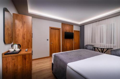 a hotel room with a bed and a television at Hotel And free shuttle in Istanbul