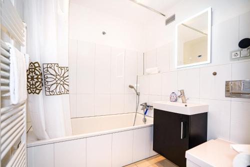 a white bathroom with a tub and a sink at Seerobbe in Hansaland