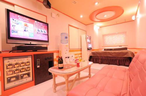 a living room with a tv and a couch and a table at STAR RESORT Will in Morioka