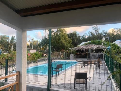 uitzicht op een zwembad met stoelen en een tafel bij Villa Koki Bonheur Rodrigues in Saint Francois