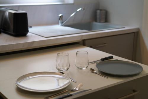 Una encimera de cocina con dos vasos y un plato y un fregadero. en Le Tertre Saint-François, en Chartres