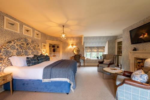 a bedroom with a large bed and a living room at The Lamb Inn in Burford