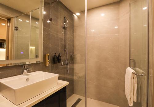 a bathroom with a sink and a shower at AR Suites Sohna Road in Gurgaon